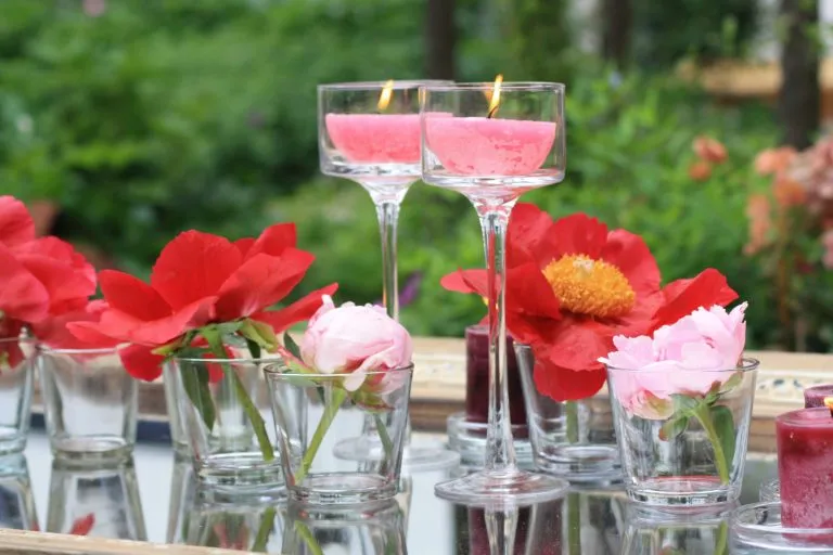 Tischdekoration mit roten Blüten und Kerzen